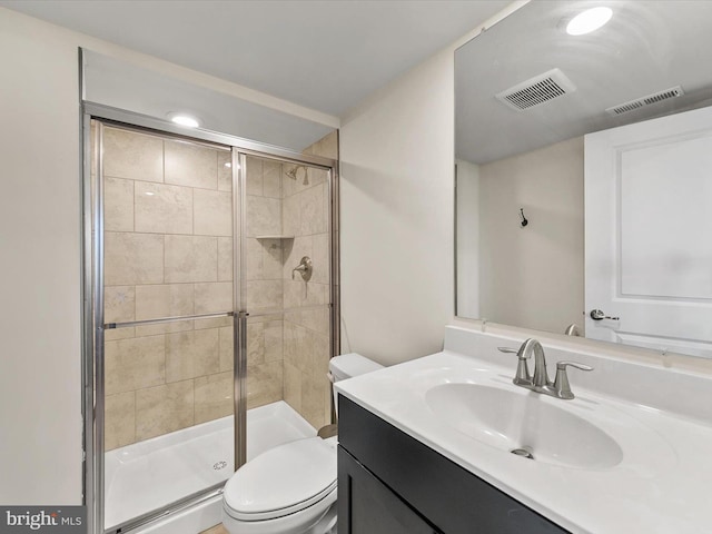 bathroom with vanity, an enclosed shower, and toilet