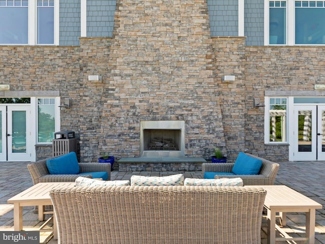 view of patio / terrace featuring french doors and an outdoor living space with a fireplace