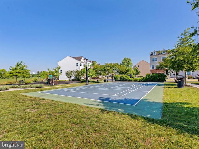 view of tennis court featuring basketball hoop, a lawn, and a playground