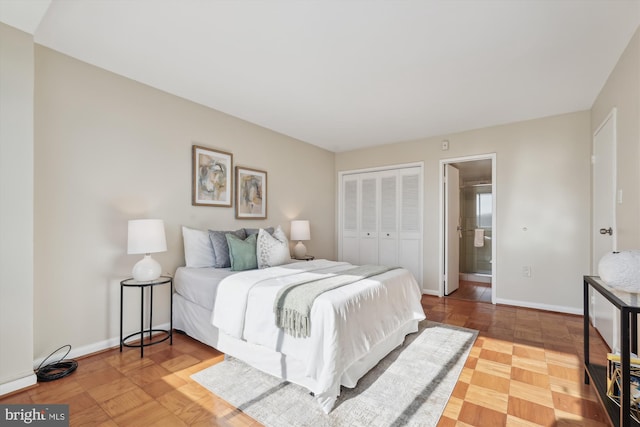 bedroom with ensuite bathroom, parquet floors, and a closet