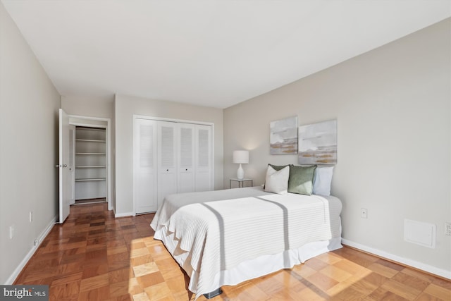 bedroom featuring parquet flooring and a closet