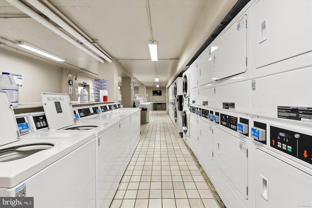 laundry area featuring stacked washer and dryer, washer and dryer, and light tile patterned floors