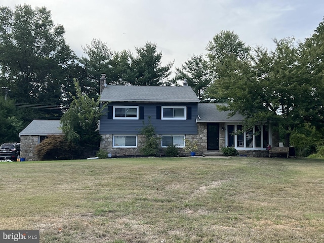 tri-level home featuring a porch and a front lawn