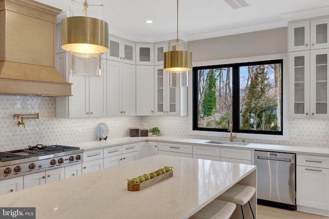 kitchen with white cabinets, glass insert cabinets, custom exhaust hood, stainless steel appliances, and a sink