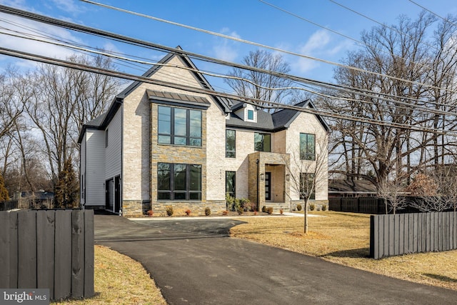 view of front of property with stone siding and fence