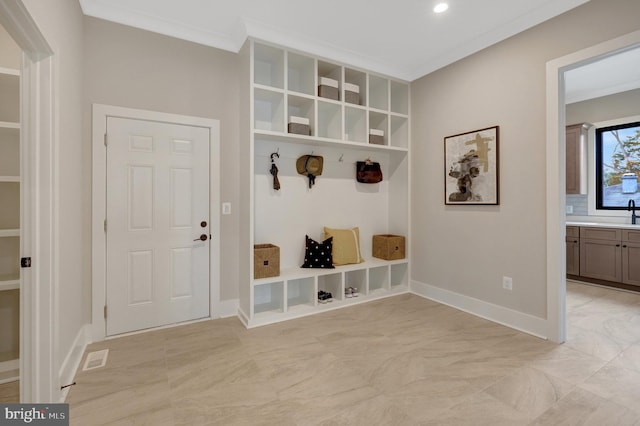 mudroom with recessed lighting, visible vents, ornamental molding, a sink, and baseboards