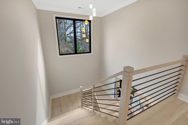 stairs featuring ornamental molding, baseboards, and wood finished floors