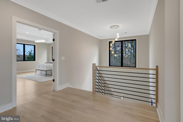 unfurnished room featuring ornamental molding, visible vents, baseboards, and wood finished floors