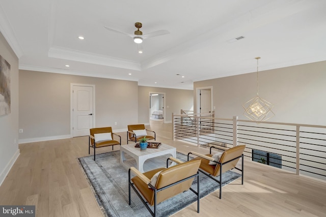 living area featuring light wood-style flooring, recessed lighting, an upstairs landing, baseboards, and a tray ceiling