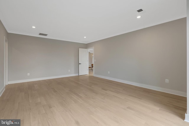 unfurnished room featuring light wood-style floors, baseboards, visible vents, and crown molding