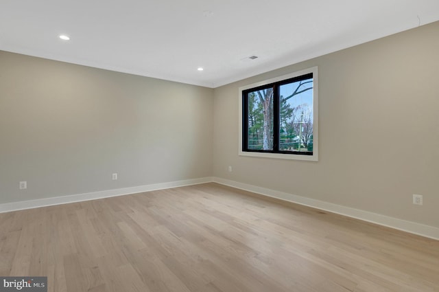 spare room featuring light wood-style floors, recessed lighting, and baseboards