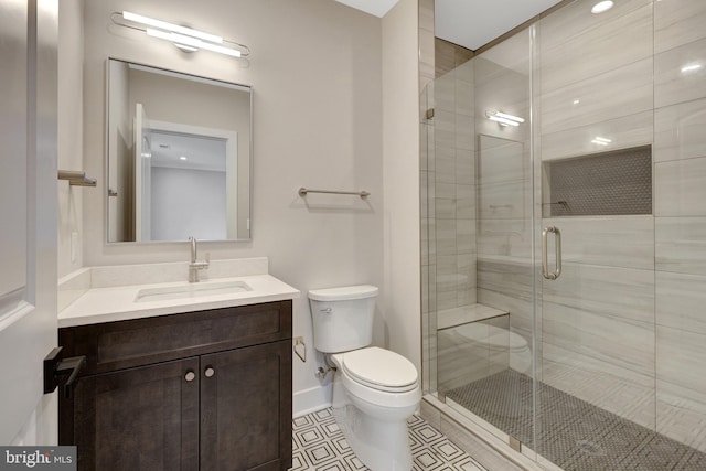 full bath with toilet, vanity, baseboards, a shower stall, and tile patterned floors