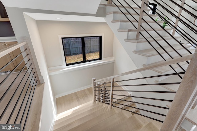 stairway featuring baseboards and wood finished floors