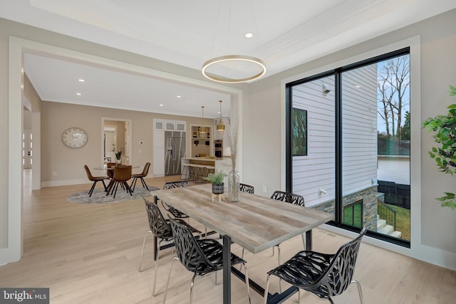 dining space featuring light wood finished floors, recessed lighting, baseboards, and ornamental molding