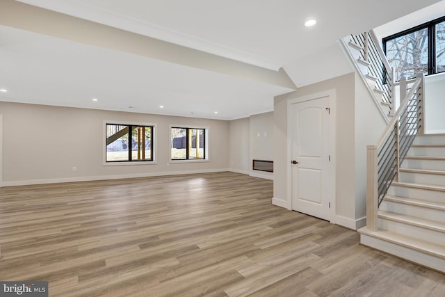 unfurnished living room with stairs, recessed lighting, baseboards, and light wood-style floors