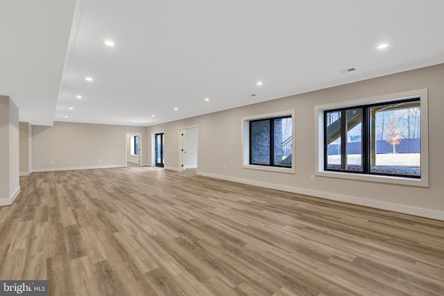 unfurnished living room featuring light wood-type flooring, baseboards, and recessed lighting