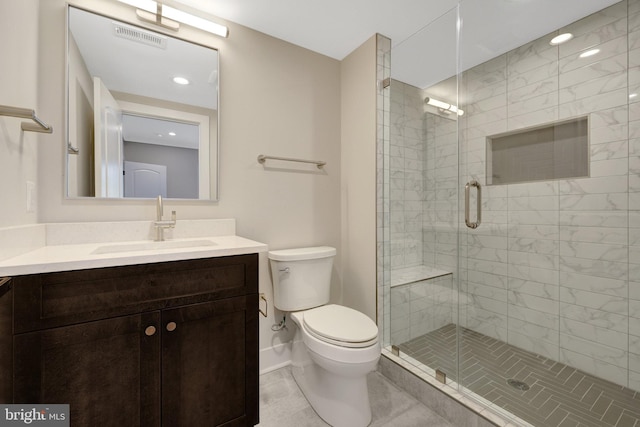 bathroom with a stall shower, baseboards, visible vents, toilet, and vanity