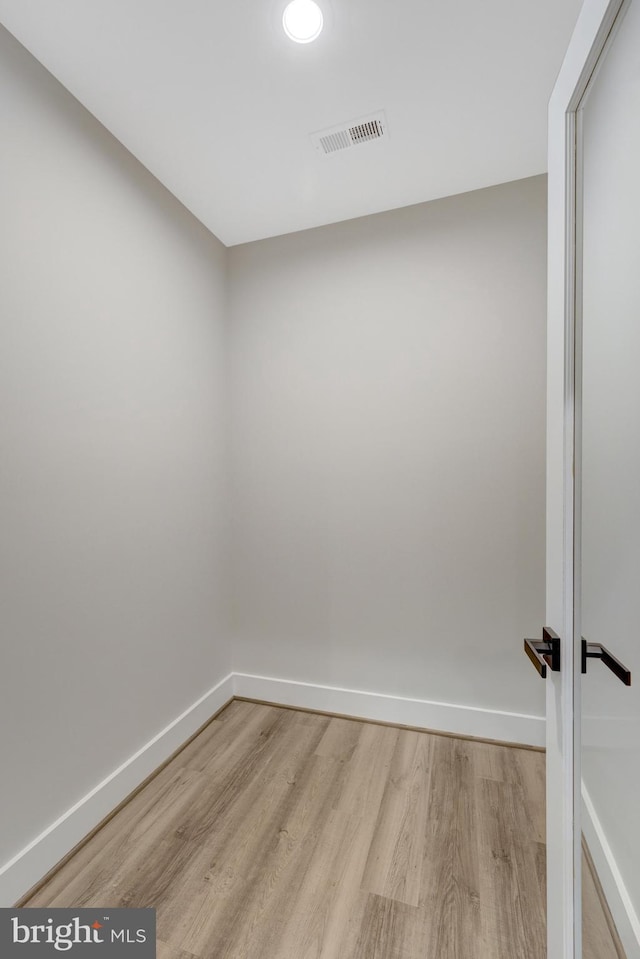 unfurnished room featuring light wood-type flooring, baseboards, and visible vents