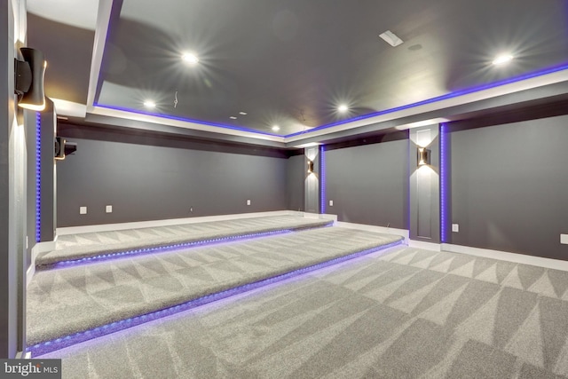 home theater featuring carpet floors, baseboards, a raised ceiling, and recessed lighting