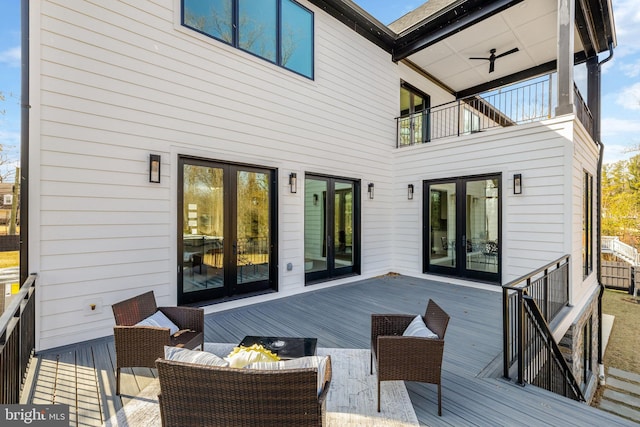 wooden deck with an outdoor hangout area, french doors, and a ceiling fan