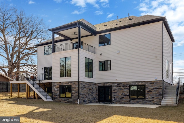 back of house featuring ceiling fan, a patio, a balcony, a yard, and stairway