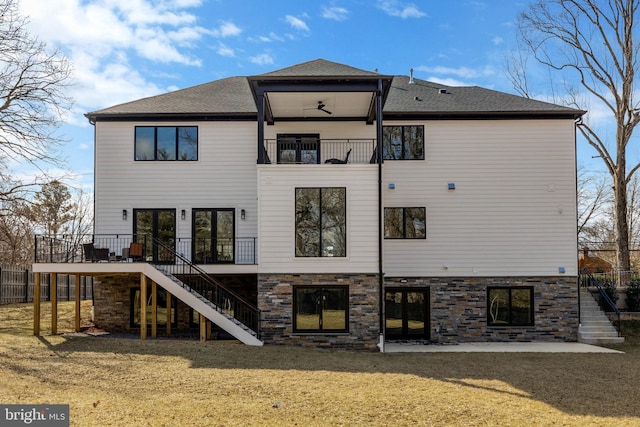 back of property featuring a patio, stairway, a balcony, and a lawn