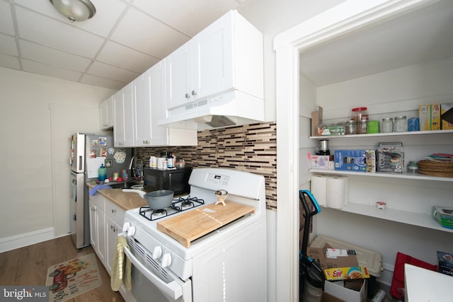 kitchen with hardwood / wood-style flooring, white range with gas stovetop, white cabinetry, backsplash, and a drop ceiling