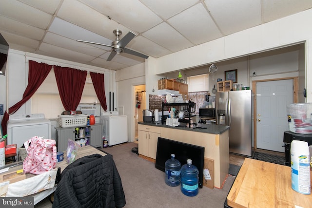 interior space featuring washer and clothes dryer, stainless steel fridge, ceiling fan, and a paneled ceiling