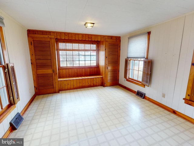 spare room featuring a healthy amount of sunlight, visible vents, and light floors