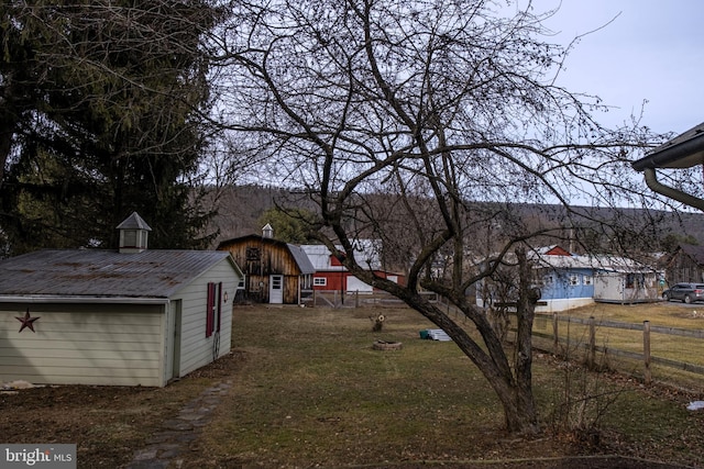 view of yard with fence and an outdoor structure