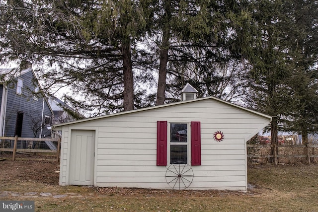 view of outbuilding with an outdoor structure and fence