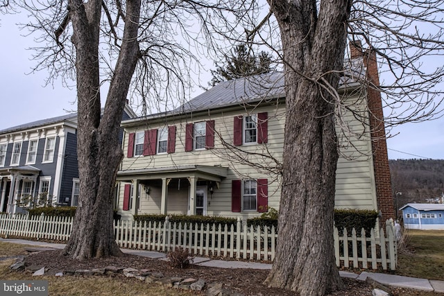 view of front of property featuring a fenced front yard and metal roof