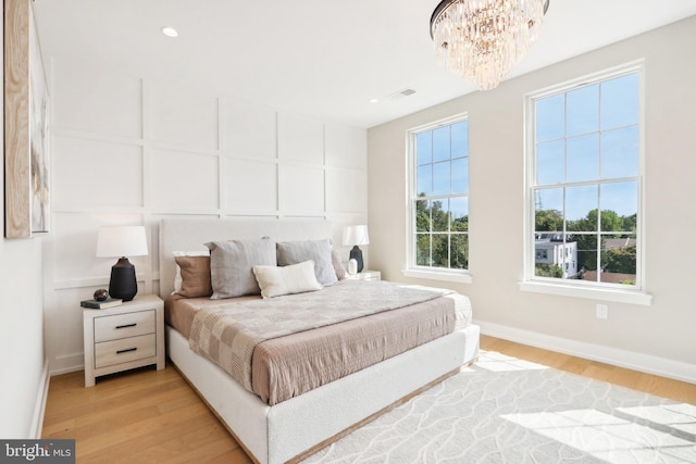 bedroom featuring a chandelier and light wood-type flooring