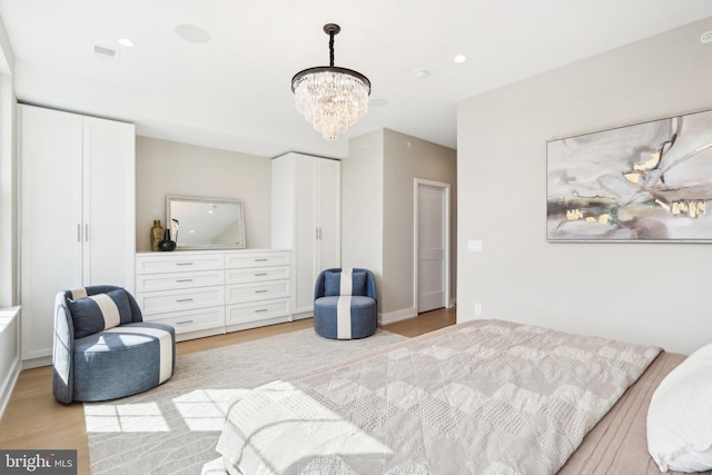 bedroom featuring a chandelier and light hardwood / wood-style floors