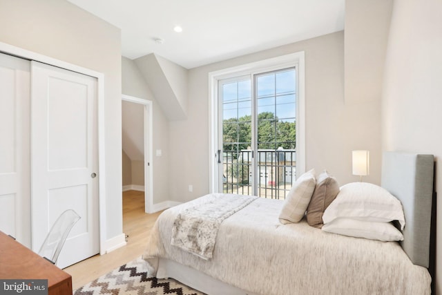 bedroom featuring access to outside, light hardwood / wood-style floors, and a closet