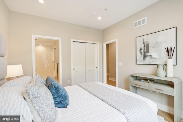 bedroom featuring wood-type flooring, a closet, and ensuite bathroom