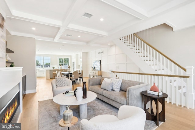 living room featuring coffered ceiling, beam ceiling, and light wood-type flooring