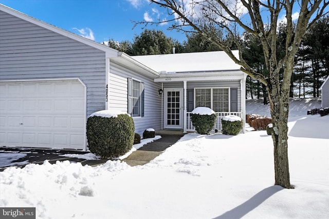 snow covered property with a garage