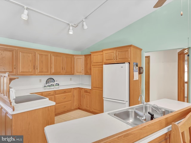 kitchen with lofted ceiling, sink, ceiling fan, white refrigerator, and light tile patterned flooring