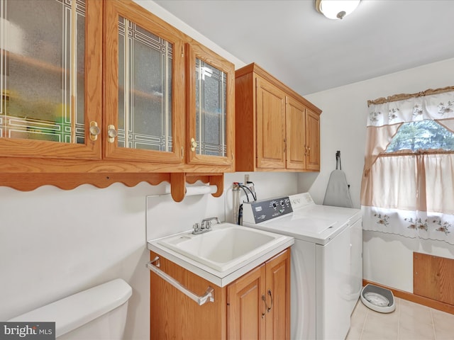 washroom featuring separate washer and dryer, sink, and light tile patterned flooring