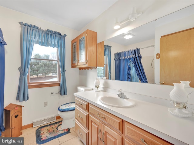 bathroom featuring walk in shower, vanity, toilet, and tile patterned flooring