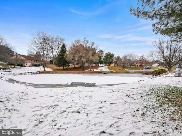 yard layered in snow featuring a water view