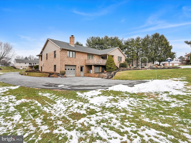 snow covered property with a garage and a yard