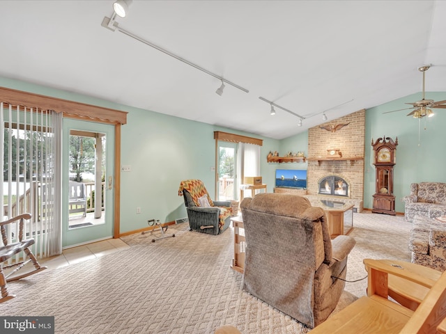 carpeted living room with lofted ceiling, a fireplace, rail lighting, and ceiling fan