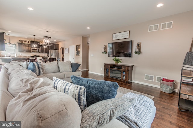 living room with dark hardwood / wood-style floors and sink