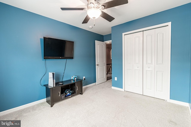 interior space with ceiling fan, light carpet, and a closet