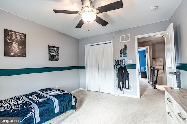 carpeted bedroom with ceiling fan and a closet