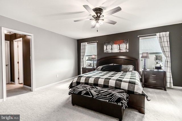 carpeted bedroom featuring multiple windows and ceiling fan