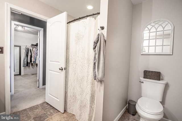 bathroom featuring curtained shower and toilet