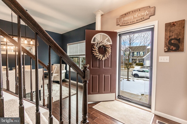 foyer entrance featuring hardwood / wood-style flooring and ornate columns